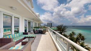 a balcony of a resort with chairs and the ocean at South Bay Beach Club #36 Penthouse - 3 Bedroom 3 Bathroom Unit in George Town