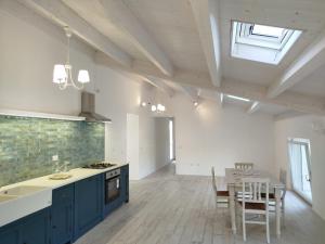 a kitchen with blue cabinets and a table and chairs at SlowCasa - VILLA Garden & Pool - Full Apartment in Torrevecchia Teatina