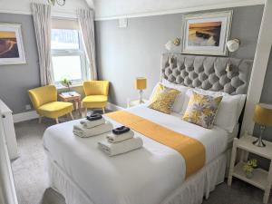Un dormitorio con una cama grande con dos toallas encima. en Sunnycroft Private Hotel, en Llandudno