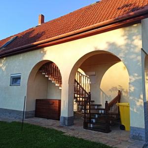 a house with a staircase and a building with a roof at Kati Appartmann in Balatonberény