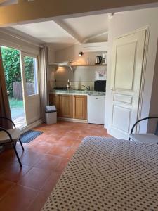 a room with a kitchen with a table and a door at Le Mazet des Mûres in Grimaud