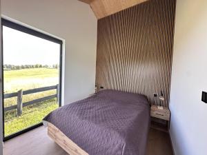 a bedroom with a bed and a large window at Oaza Żuraw in Miłki +15 photos