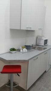 a kitchen with a counter with a microwave and a red stool at La Suite in Civitanova Marche +46 photos