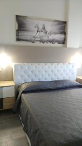 um quarto com uma cama e um quadro na parede em La Suite em Civitanova Marche