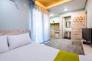 a bedroom with a white bed and a television at White star in Jeju
