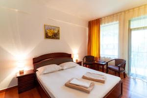ein Schlafzimmer mit einem Bett mit zwei Handtüchern darauf in der Unterkunft Hotel Victoria in Costinești