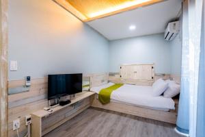 a bedroom with a bed and a flat screen tv at White star in Jeju