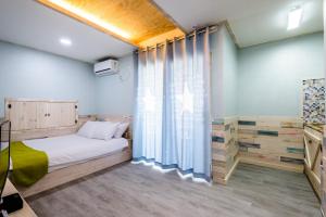 a bedroom with a bed and a large window at White star in Jeju