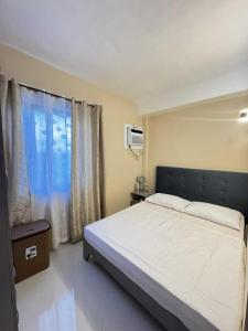 Un dormitorio con una cama grande y una ventana en Rhiangelo Condo Suite in Cebu City, en Cebú