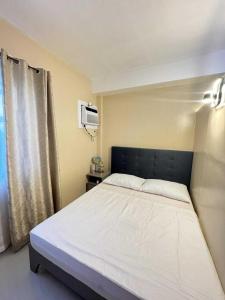 Un dormitorio con una cama con cabecero negro. en Rhiangelo Condo Suite in Cebu City, en Cebú 89 fotos más