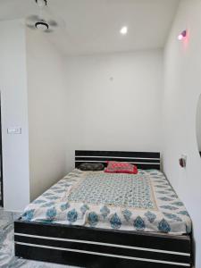 una cama en una habitación con una pared blanca en Pandit Devki Nandan Dharamsala & Guest House, en Deoghar 18 fotos más
