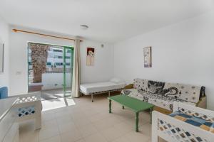 een woonkamer met een bank en een tafel bij Alondras Apartamento E107 in Costa Del Silencio +16 foto's