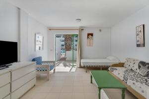 een woonkamer met een bank en een tv bij Alondras Apartamento E107 in Costa Del Silencio