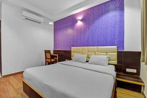 ジャイプールにあるHotel Karma Inn I Hotel Near To Jaipur Airportの紫の壁のベッドルーム1室(大型ベッド1台付)