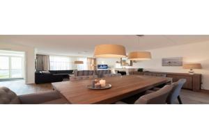 a living room with a large wooden table and chairs at Holiday home with whirlpool and sauna in a quiet area in Zeeland in Colijnsplaat