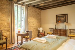 ein Schlafzimmer mit einem Bett und einem Tisch und Stühlen in der Unterkunft Domaine de Prunget - Pierres d'Histoire in Tendu