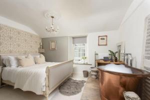 a bedroom with a bed and a tub in it at Almond Cottage - Pets welcome - Free Parking - Garden in Hayle