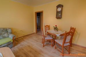 a living room with a table and chairs and a clock at Helene in Hüttenrode