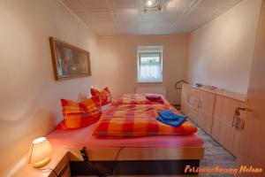 a bedroom with a bed with red and orange pillows at Helene in Hüttenrode