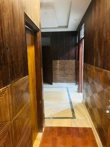 an empty room with wood paneled walls and a hallway at Laxmi Inn Guest House in New Delhi