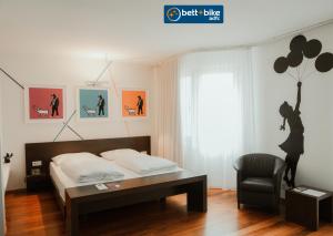 林茨arte Hotel Linz的一间卧室配有一张床、一把椅子和气球