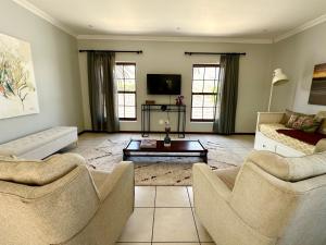 a living room with two chairs and a couch at Spacious Retreat with Mountain Views in Fish hoek