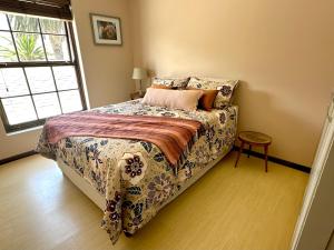 a bedroom with a bed and a window at Spacious Retreat with Mountain Views in Fish hoek