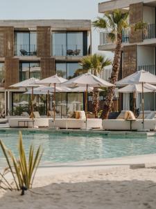 a swimming pool with chairs and umbrellas at Bonito Ibiza by O Beach - New Opening 2025 in San Antonio +58 photos