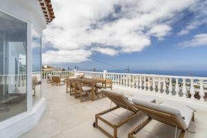 a balcony with a table and chairs and the ocean at Casa Xuixo in Tenerife South in Guía de Isora