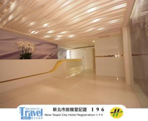 a hallway in a building with a vase of flowers at Hotel Purity in Xinzhuang