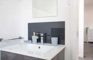 Un lavabo blanco en un baño con espejo. en 4 Storr Place, en Portree 23 fotos más