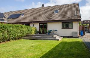 una casa con césped delante en 4 Storr Place, en Portree