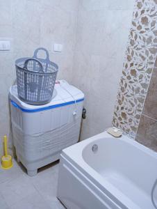 a bathroom with a tub and a basket on top of a toilet at Pink Horizon Homestay - for Families ONLY in Dumyāţ al Jadīdah +7 photos
