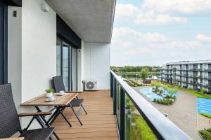 a balcony with a table and chairs and a view of a building at Stela Water Side Apartment - Swimming Pool & Sauna by Renters Prestige in Dziwnów