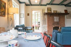 a dining room with a table and a fireplace at Vakantiewoning Hosa Semna in de duinen van Vrouwenpolder in Vrouwenpolder +51 photos
