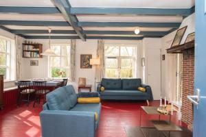 a living room with blue couches and a table at Vakantiewoning Hosa Semna in de duinen van Vrouwenpolder in Vrouwenpolder