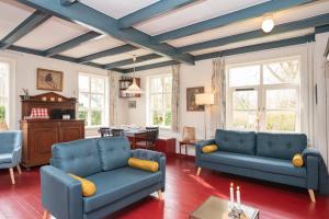 a living room with blue couches and a table at Vakantiewoning Hosa Semna in de duinen van Vrouwenpolder in Vrouwenpolder
