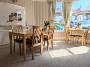 Un comedor con mesa y sillas y una ventana. en Sunnycroft Private Hotel, en Llandudno