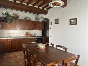 a kitchen with a wooden table and some chairs at Agriturismo Casa Paradiso in Cortona