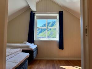 a room with two beds and a window at Ballstad Tide House - Lofoten in Ballstad