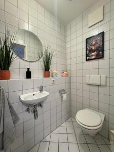 a white bathroom with a toilet and a sink at Familienapartment Buehlertal bei Buehl Baden Baden und Schwarzwald in Bühlertal