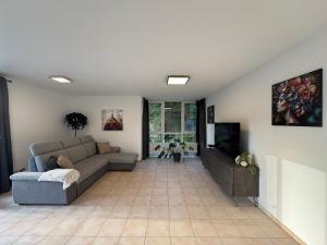 ビューラータールにあるFamilienapartment Buehlertal bei Buehl Baden Baden und Schwarzwaldのソファとテレビのあるリビングルーム