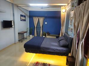 a blue bedroom with a bed and a couch at The Urban Homestay Premium Floating Bed AC Room Free Parking in Dibrugarh