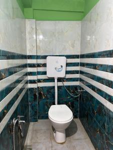 a bathroom with a toilet with blue and white stripes at Ahar Hotel in Badarpur +9 photos