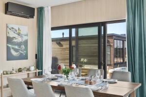 a dining room with a table and chairs and a large window at Artic Lyngvær Luggombu Lodge with jacuzzi in Kleppstad