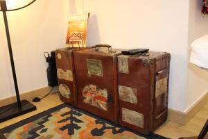 una vecchia valigia appoggiata sul pavimento accanto a una lampada di Cozy Apartment Elvas II a Elvas