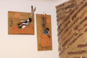 due statuette di legno di una mucca su un muro di Cozy Apartment Elvas II a Elvas