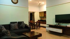 a living room with a couch and a flat screen tv at Royal Service apartment - KK Nagar Madurai in Madurai