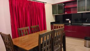 a dining room with a red curtain and a table and chairs at Royal Service apartment - KK Nagar Madurai in Madurai