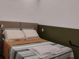 a bed with two pillows on top of it at Studio 102 Cop 30 in Curro Velho